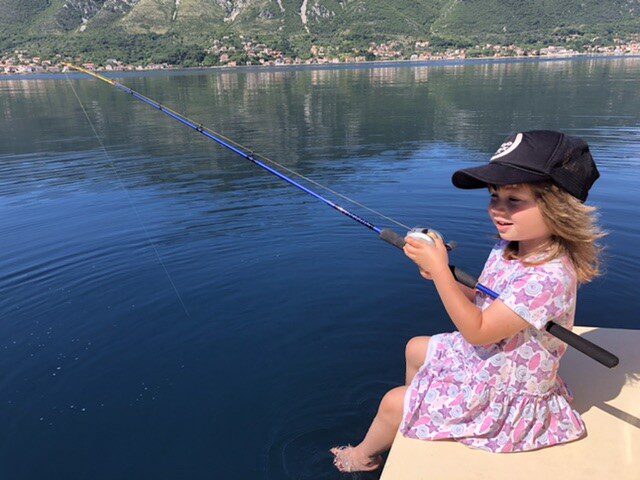 fishing for kids - Ivan's daughter Lara holding a fishing rod in the back of the boat