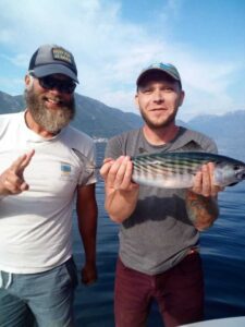List of Boat Tours - Captain Ivan with a happy guest holding an atlantic bonito freshly caught